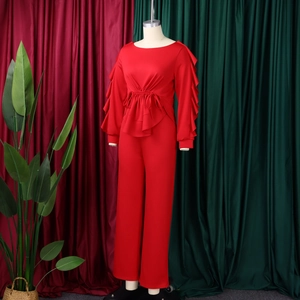 Detail eines roten eleganten Langarm-Jumpsuits mit Volantärmeln und Kordelzug in der Taille