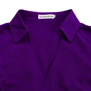 Detail shot of purple V-neck dress collar with size S brand label and fine woven fabric