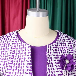 Détail de la veste imprimée violette avec une broche fleurie en perles sur mannequin