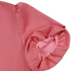 Detailed macro view of pink puff sleeve ruffles and stitching on fashionable V-neck dress