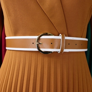 Detail of caramel pleated dress with leather belt and golden buckle showing fabric texture