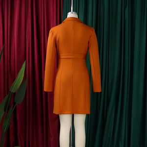 Rear view of sleek orange double-breasted blazer dress with waist tie and slim fit cut