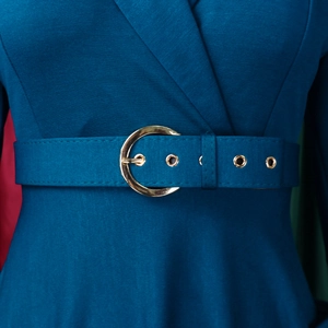 Détail de la ceinture à boucle dorée sur une robe vert foncé avec tissu texturé
