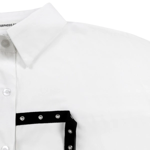 Macro detail of shirt collar with black ribbon and silver metal eyelet decorations