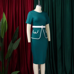 Dettaglio dell'abito aderente verde scuro OL con cintura bianca e finiture a contrasto