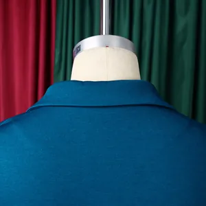 Détail du dos de la robe bleu canard montrant la texture côtelée et le col tailleur