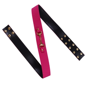 Détail de la sangle en toile fuchsia et cuir noir avec mors doré et œillets en métal