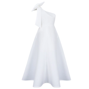 Detail of elegant white one-shoulder dress featuring a large sculptural bow ornament