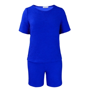 Détail du tissu gaufré bleu roi et de l'étiquette au col de cet ensemble deux pièces