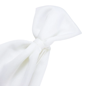Macro detail of a large white fabric bow accent on an elegant one-shoulder evening dress