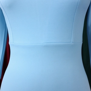 Macro shot of precise waist stitching and fine fabric texture on light blue dress