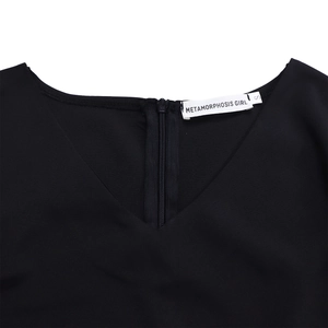 Detail view of the V-neckline and back zipper closure on a black elegant A-line dress