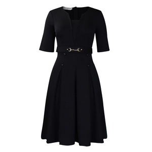 Détails de la robe noire avec col en V, boucle dorée à la taille et jupe trapèze plissée