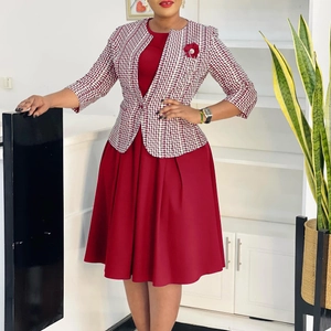 Détail d'une robe rouge et d'une veste à pied-de-poule avec broche florale