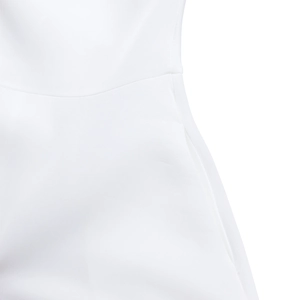 Detailed macro view of high-quality white woven fabric seams and side pocket design on dress