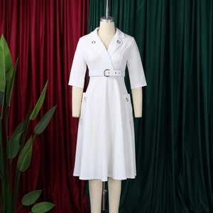 Détail d'une élégante robe blanche mi-longue avec col en V et ceinture à la taille