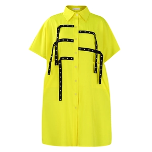 Detailed view of yellow shirt dress featuring black tape with silver metal eyelets