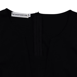 Détail de l'encolure de la robe noire avec fermeture éclair au dos et étiquettes tissées