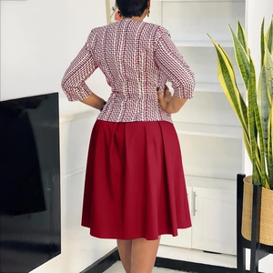 Vue arrière de l'ensemble africain avec veste rouge et blanc et jupe plissée