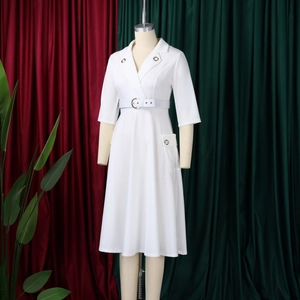 Détail d'une robe blazer blanche avec col à revers et ceinture à œillets métalliques