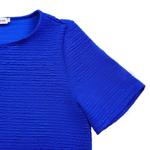 Gros plan détaillé du tissu gaufré texturé et de l'encolure du haut de couleur bleue
