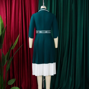 Detailed back view of dark green pleated A-line dress with contrasting white hem and belt
