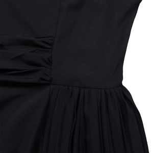 Detailed macro view of black pleated fabric with clean stitching and waist pleats