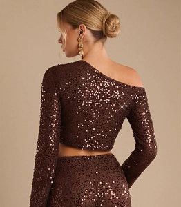 Dettaglio del tessuto con paillettes marrone scuro e della cerniera invisibile sul retro