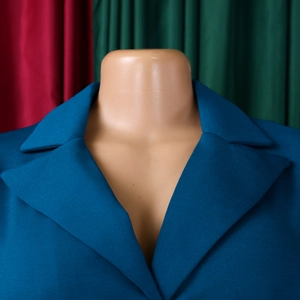 Détail de la robe bleu paon avec col à revers et texture de tissu tissé sophistiquée