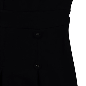 Détail de deux boutons noirs avec anneaux métalliques sur la taille d'une robe tissée