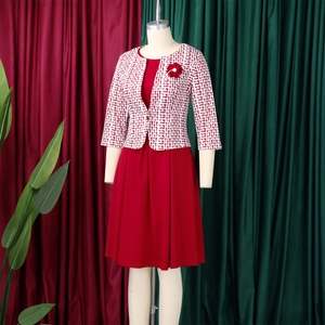 Détail de l'ensemble robe deux pièces rouge avec veste géométrique et broche fleur
