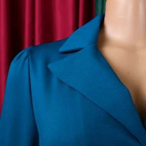Détail du col à revers classique et de l'épaule plissée sur ce blazer bleu pétrole