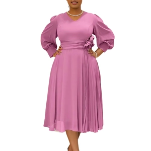 Detail of V-neck dusty pink dress featuring waist flower accent and pleated skirt