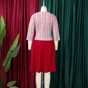 Détail de la robe à imprimé africain avec jupe plissée rouge et manches géométriques