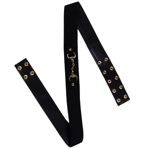 Détail de large ceinture en cuir noir avec boucle mors dorée et œillets métalliques