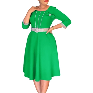 Detail of elegant green dress featuring plaid patterns on the belt, cuffs and neckline