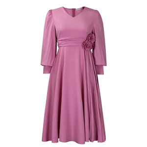 Detail view of V-neck pink dress featuring pleated waist and handmade 3D floral accents