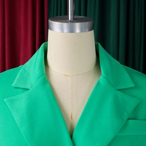 Detailed view of vibrant green blazer dress featuring notched lapels and structured shoulders