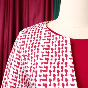 Détail d'un gilet pour femme avec motifs géométriques rouge et blanc et coupe du col soignée