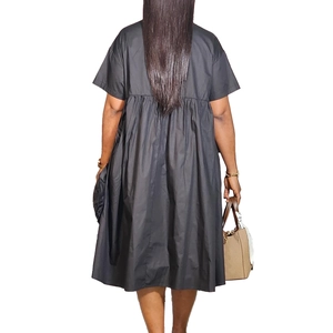 Back view of a black short sleeve A-line midi dress with high waist pleated skirt detail