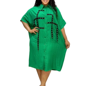 Detail of green plus size shirt dress with black rivet ribbon grid and button front