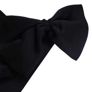 Detail of a large black matte satin bow accessory with an elegant three-tier structure