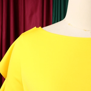 Detail des eleganten gelben Off-Shoulder-Oberteils mit Rüschenärmeln und glattem Stoff