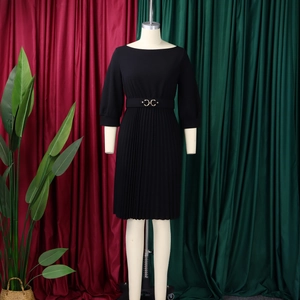 Dettaglio elegante abito midi nero a pieghe con fibbia della cintura dorata