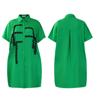 Detail of green shirt dress with cross-straps, eyelets, and asymmetric industrial design
