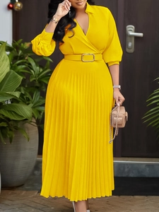 Elegant yellow V-neck maxi dress with pleated skirt and waist belt in a spring garden setting