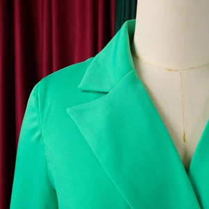 Detail of emerald green blazer with classic notched lapels and textured woven fabric