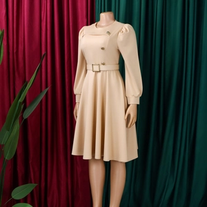 Dettaglio vestito beige linea A con maniche a sbuffo, bottoni dorati e cintura