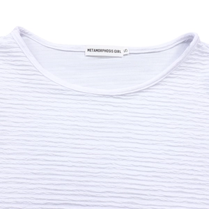 Détail de la texture gaufrée et col rond avec étiquette de marque en taille S