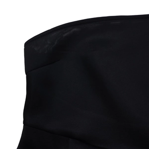 Detailed close-up of premium black fabric with reinforced stitching on the shoulder neckline